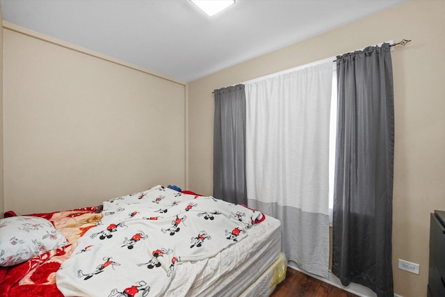 bedroom with dark wood-style flooring