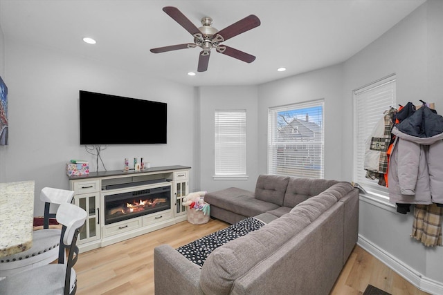 living room featuring a ceiling fan, recessed lighting, wood finished floors, and baseboards