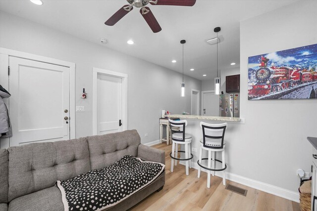 living area with light wood finished floors, recessed lighting, baseboards, and a ceiling fan