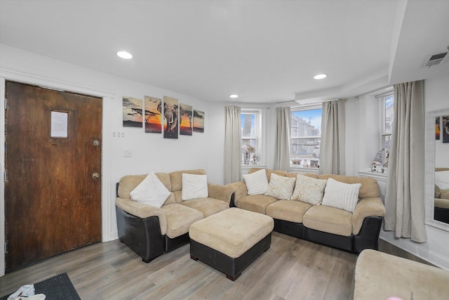 living room with recessed lighting, visible vents, and light wood-style flooring