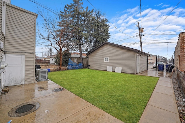 view of yard featuring a patio area, central air condition unit, fence, and an outbuilding