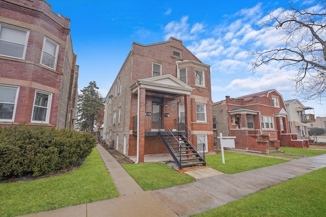 view of front of property with a front lawn, brick siding, and a residential view