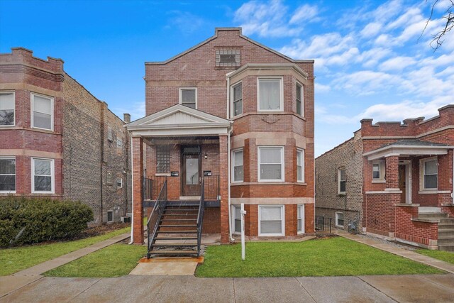 view of front of home featuring brick siding and a front lawn