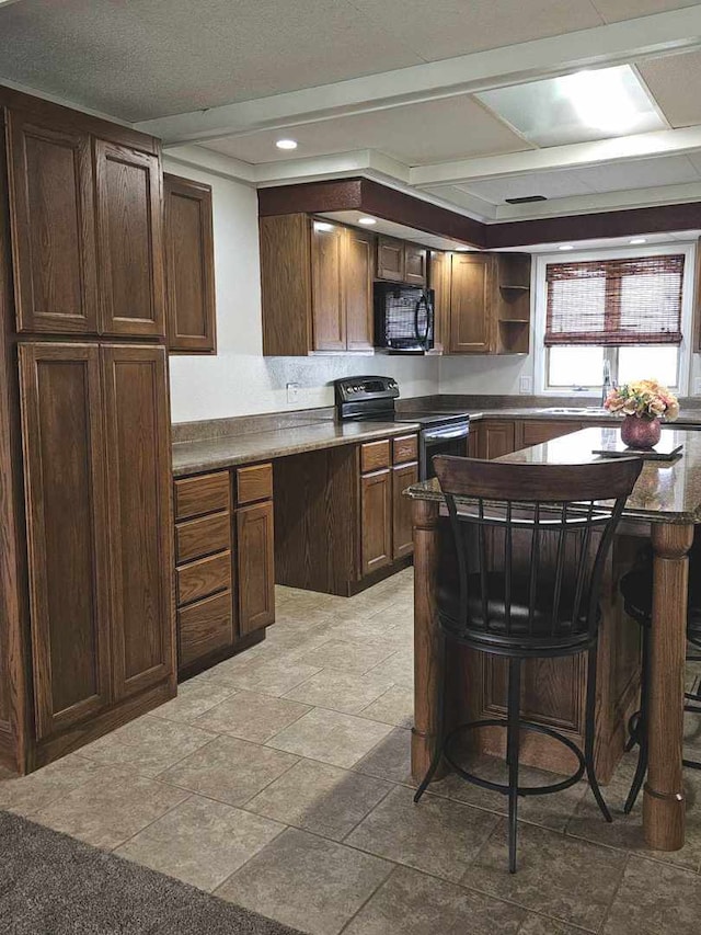 400 S 2nd St, Wapella, IL 61777 - kitchen with black appliances, open shelves, light stone finish floors, recessed lighting, and a kitchen breakfast bar