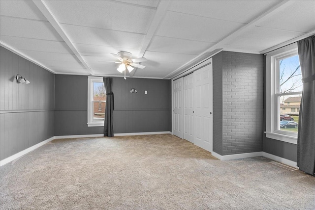 400 S 2nd St, Wapella, IL 61777 - unfurnished bedroom with multiple windows, carpet, baseboards, and wood walls