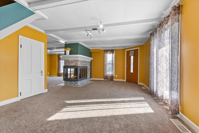 400 S 2nd St, Wapella, IL 61777 - unfurnished living room featuring carpet, a multi sided fireplace, baseboards, and beamed ceiling