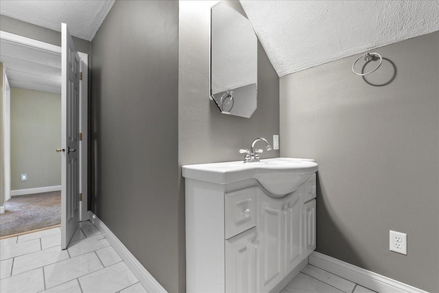 400 S 2nd St, Wapella, IL 61777 - bathroom with marble look tile flooring, a textured ceiling, vanity, and baseboards
