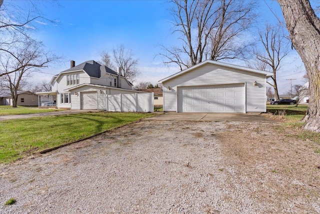 400 S 2nd St, Wapella, IL 61777 - view of property exterior featuring a chimney, a detached garage, an outdoor structure, a lawn, and a gambrel roof