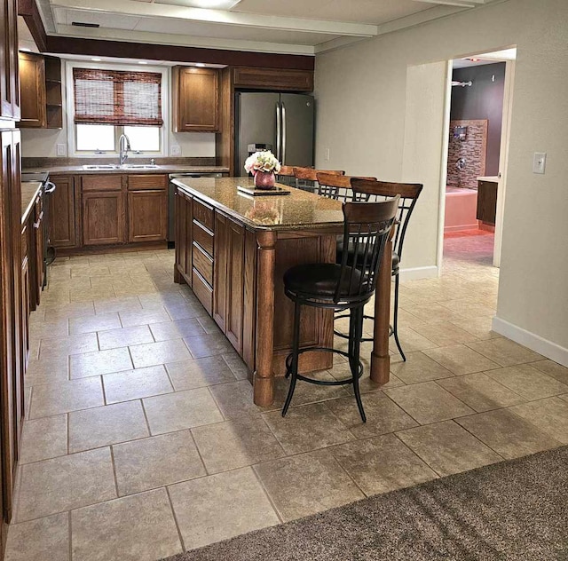 400 S 2nd St, Wapella, IL 61777 - kitchen featuring stainless steel fridge, a sink, baseboards, a center island, and a breakfast bar area