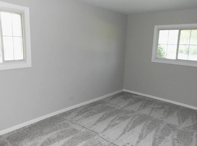 carpeted spare room with baseboards