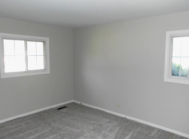 spare room with baseboards, visible vents, and carpet floors