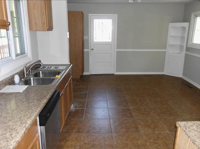 kitchen featuring stainless steel dishwasher, a healthy amount of sunlight, brown cabinets, and a sink