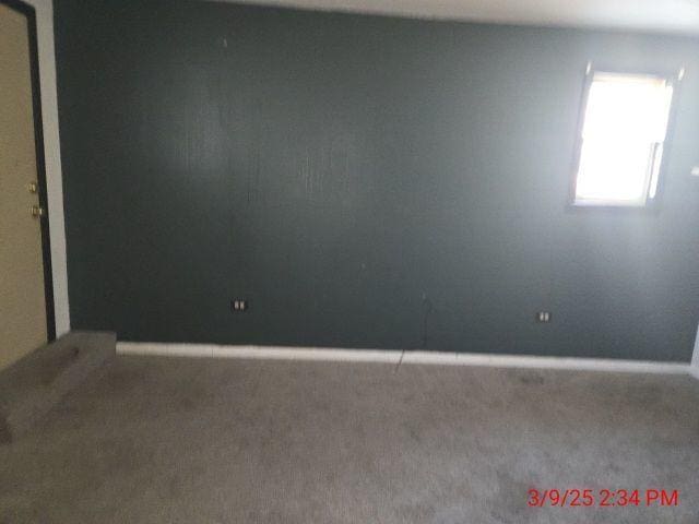 unfurnished room with baseboards and carpet