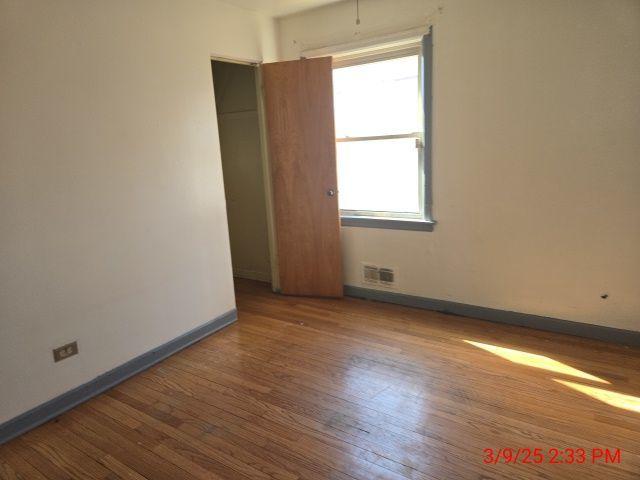 unfurnished room with visible vents, baseboards, and wood finished floors