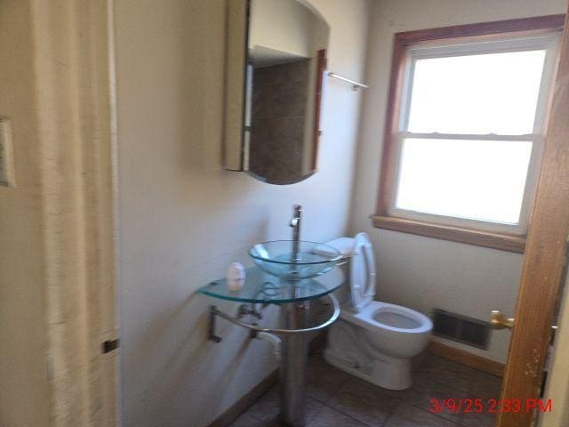 bathroom featuring visible vents, toilet, and tile patterned flooring