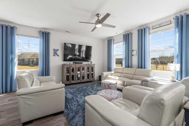 living room with visible vents, a ceiling fan, and wood finished floors