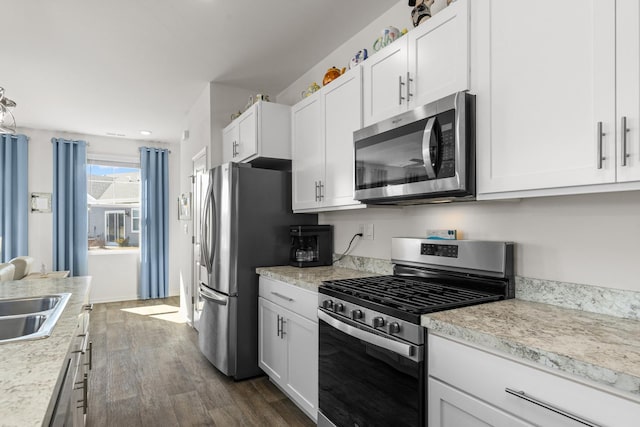 kitchen with dark wood finished floors, a sink, light countertops, appliances with stainless steel finishes, and white cabinetry