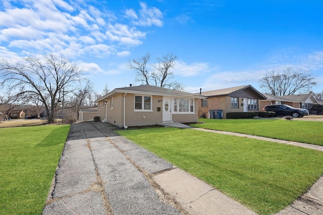 view of front of home with a front lawn, concrete driveway, and brick siding