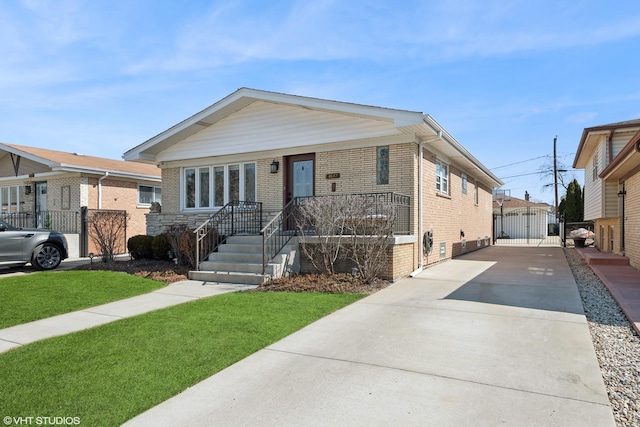 view of front facade featuring fence, brick siding, driveway, and a gate