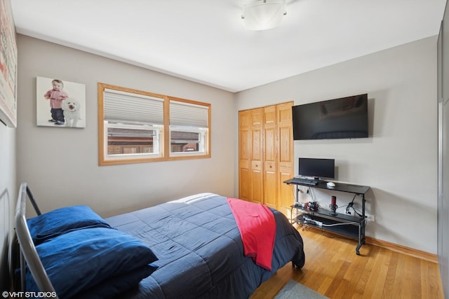 bedroom with a closet, baseboards, and wood finished floors