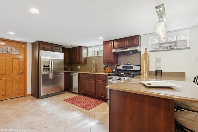 kitchen with visible vents, a peninsula, stainless steel appliances, under cabinet range hood, and backsplash