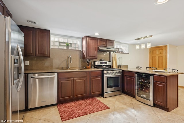 kitchen with wine cooler, under cabinet range hood, a peninsula, stainless steel appliances, and a sink