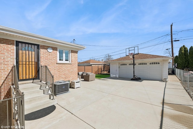 exterior space with an outdoor living space, a detached garage, fence, central air condition unit, and an outbuilding