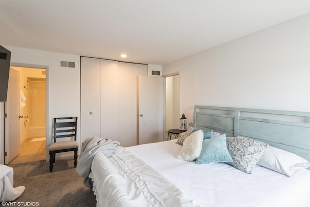 carpeted bedroom with ensuite bath, recessed lighting, visible vents, and a closet