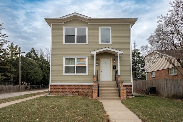 traditional-style home featuring a front lawn and fence