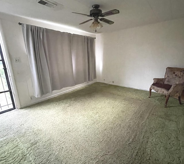 carpeted empty room with visible vents and ceiling fan