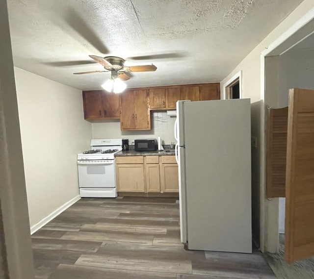 kitchen with white appliances, dark wood finished floors, ceiling fan, a textured ceiling, and dark countertops