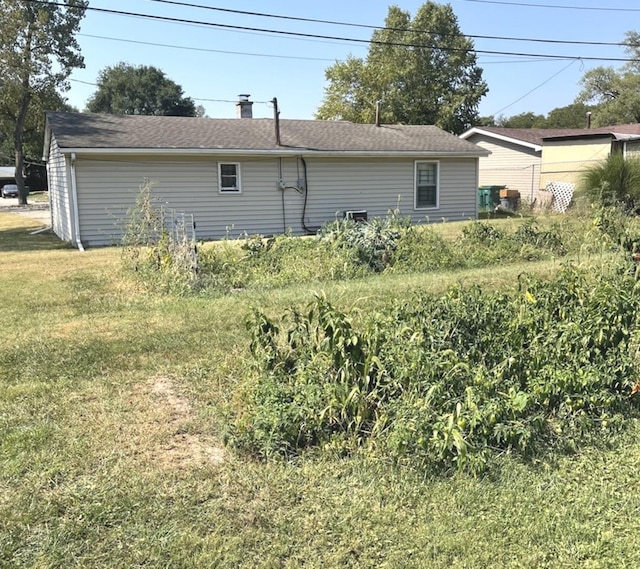 back of property featuring a lawn and a chimney