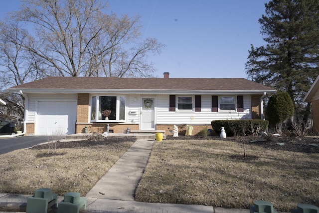 ranch-style home featuring a garage, brick siding, a chimney, and aphalt driveway