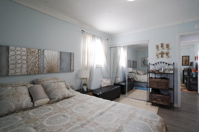 bedroom featuring a closet, wood finished floors, and ornamental molding