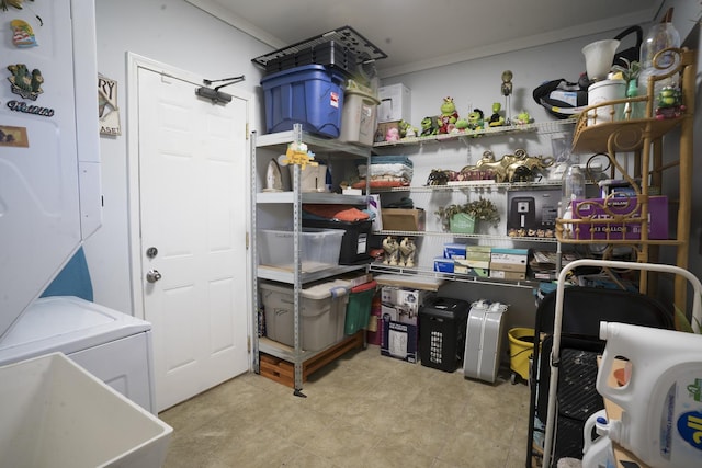 storage room featuring stacked washer / drying machine and a sink