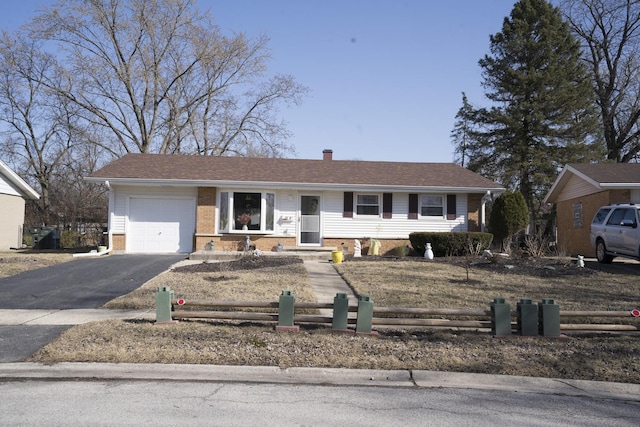 ranch-style home with an attached garage, fence, and brick siding