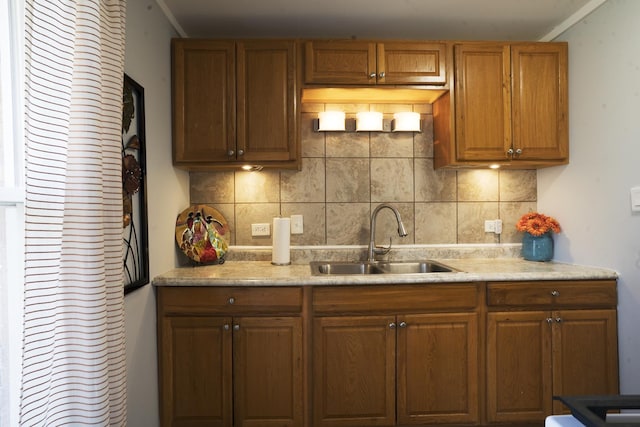 kitchen with light countertops, tasteful backsplash, and a sink