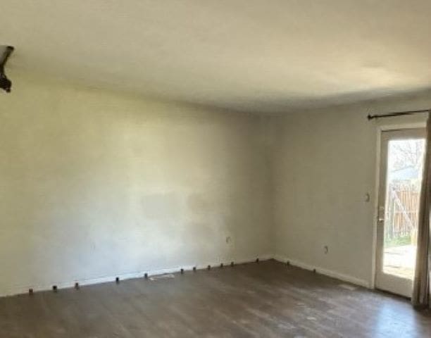 unfurnished room featuring wood finished floors and baseboards