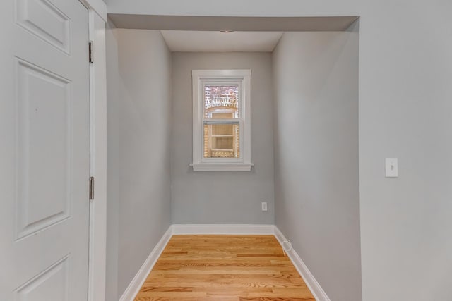 interior space with baseboards and light wood finished floors