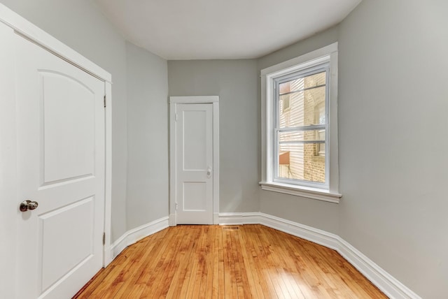 unfurnished bedroom featuring visible vents, baseboards, and light wood-type flooring