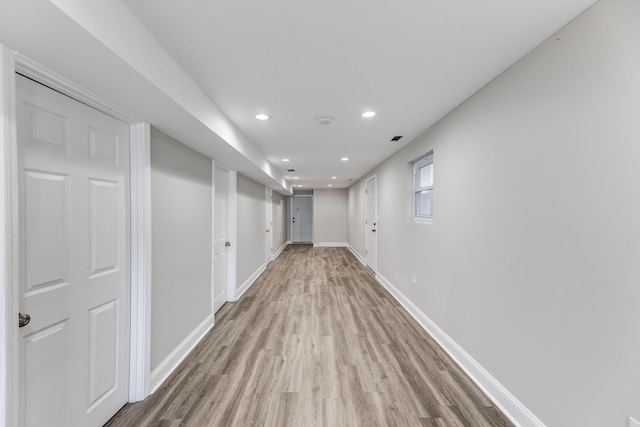 hall featuring light wood-style flooring, recessed lighting, and baseboards