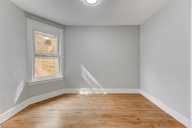 empty room with light wood-style flooring and baseboards