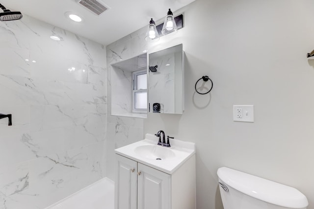 bathroom with visible vents, toilet, walk in shower, and vanity