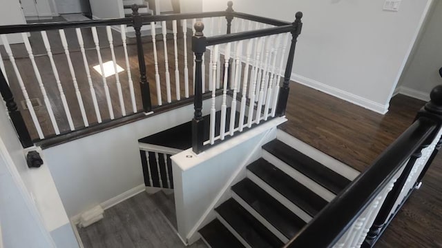 staircase with baseboards and wood finished floors