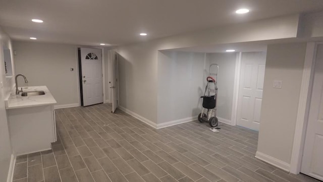 interior space with recessed lighting, wood finished floors, baseboards, and a sink