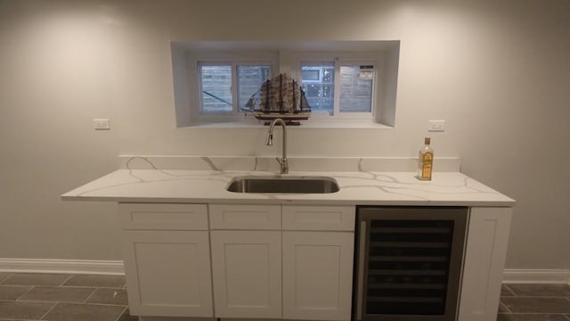 bar with baseboards, dark tile patterned flooring, a sink, bar, and wine cooler