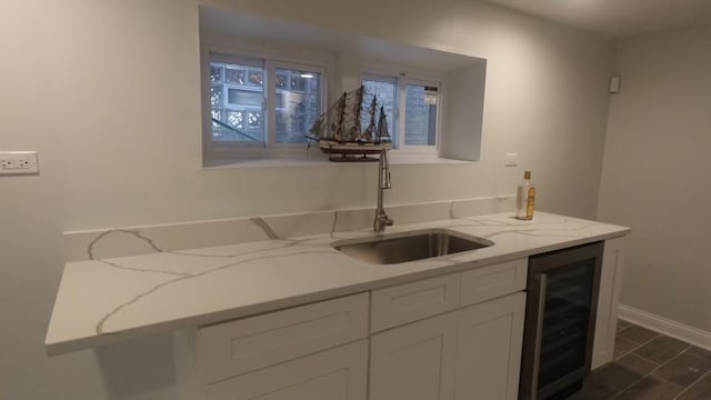 bar with wine cooler, baseboards, and a sink