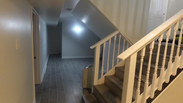 staircase with visible vents, baseboards, and wood tiled floor