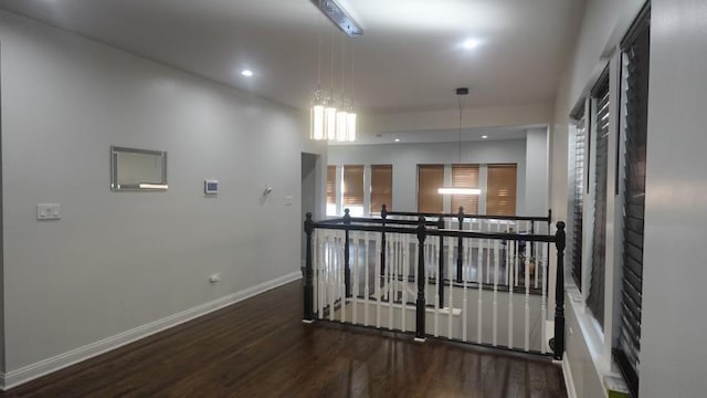 corridor with an upstairs landing, recessed lighting, baseboards, and wood finished floors