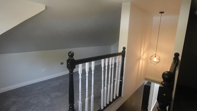 stairway featuring baseboards, carpet, and vaulted ceiling